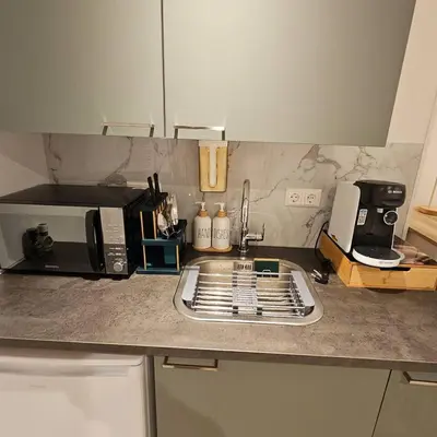 a kitchen counter with a sink and a microwave at Charming Apartment in Lisse - 30 sqm with Terrace in Lisse