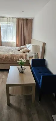 a living room with a blue chair and a coffee table at Charming Apartment in Lisse - 30 sqm with Terrace in Lisse