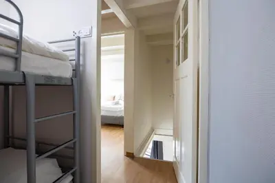 a room with two bunk beds and a mirror at Tulip Marina - garden sauna in Nieuwe-Niedorp