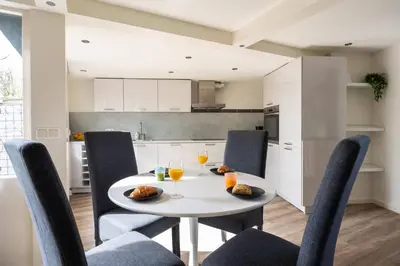 a kitchen and dining room with a white table and chairs at Tulip Marina - garden sauna in Nieuwe-Niedorp