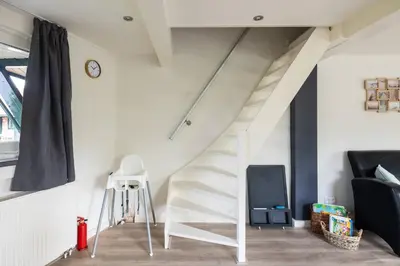 a white staircase in a living room with a stool at Tulip Marina - garden sauna in Nieuwe-Niedorp
