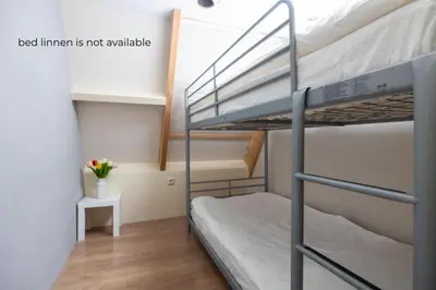 a room with two bunk beds and a desk at Tulip Marina - garden sauna in Nieuwe-Niedorp