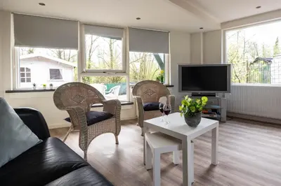 a living room with a couch and chairs and a tv at Tulip Marina - garden sauna in Nieuwe-Niedorp