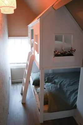 a childs bunk bed in a room with a ladder at Het Warme nest in Noordwijkerhout
