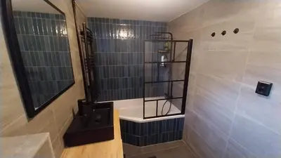 a bathroom with a shower with a sink and a mirror at Het Warme nest in Noordwijkerhout