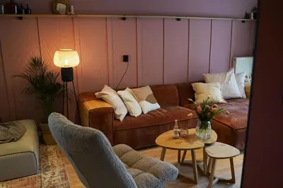 a living room with a couch and a table at Het Warme nest in Noordwijkerhout