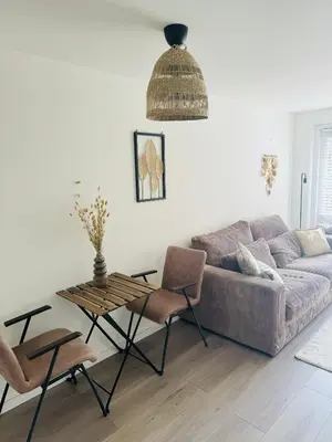 a living room with a couch and a table and chairs at Hello Noordwijk - Zomerhuis Quarles van Uffordstraat in Noordwijk aan Zee