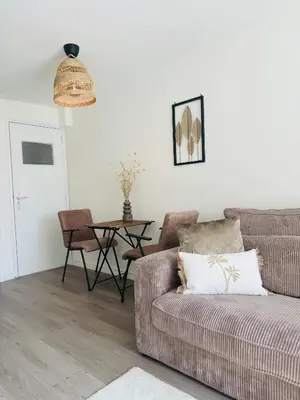 a living room with a couch and a table at Hello Noordwijk - Zomerhuis Quarles van Uffordstraat in Noordwijk aan Zee
