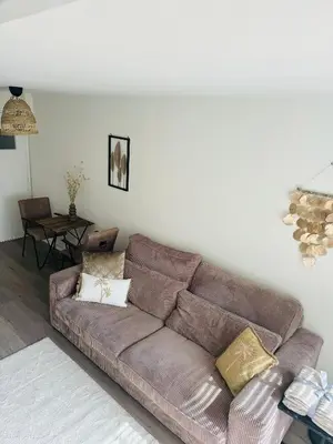 a living room with a brown couch and a table at Hello Noordwijk - Zomerhuis Quarles van Uffordstraat in Noordwijk aan Zee