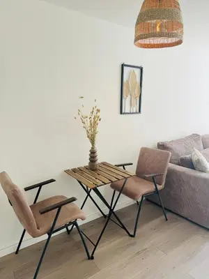 a table and chairs in a living room with a couch at Hello Noordwijk - Zomerhuis Quarles van Uffordstraat in Noordwijk aan Zee