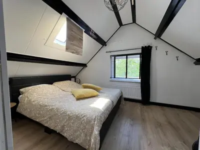 a bedroom with a bed with yellow pillows on it at Snijders cottage in Noordwijkerhout