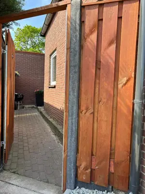 a wooden gate in front of a brick building at Snijders cottage in Noordwijkerhout