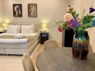 a bedroom with a bed and a table with a vase of flowers at Amsterdam Grachtenappartement in Amsterdam