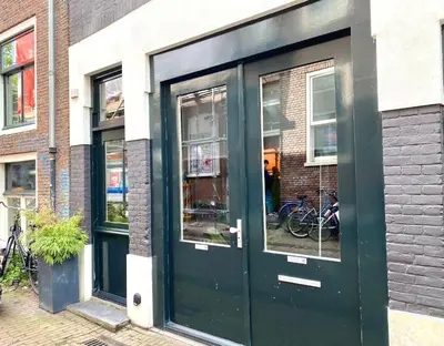 a green door on the side of a building at Amsterdam Grachtenappartement in Amsterdam