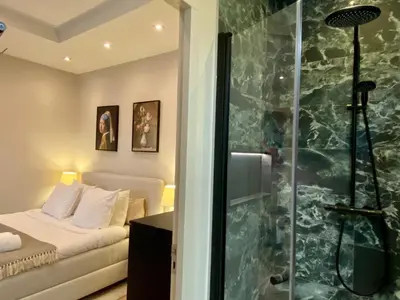 a bathroom with a shower and a bed in a room at Amsterdam Grachtenappartement in Amsterdam