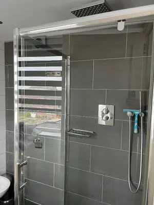 a shower with a glass door in a bathroom at Hammond Studio Apartments in Zandvoort