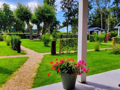 a garden with flowers in a pot on a porch at Park De Driesprong in Nieuwveen