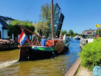 a boat with a flag is in the water at Park De Driesprong in Nieuwveen