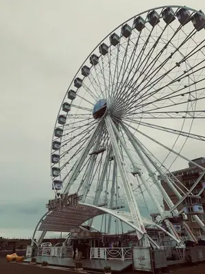 a large ferris wheel in front of a building at Have a nice stay! - Main Street beachapartment, beach 150 meters in Noordwijk aan Zee