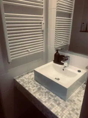a bathroom with a sink and a mirror at Have a nice stay! - Main Street beachapartment, beach 150 meters in Noordwijk aan Zee