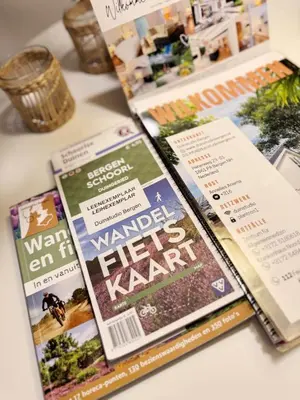 a pile of magazines sitting on top of a table at Duin Cottage Bergen in Bergen