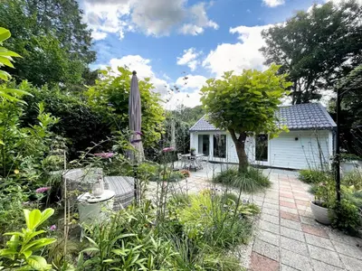 a garden with a patio and a house at Duin Cottage Bergen in Bergen