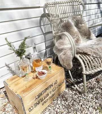a table with two glasses of wine and a chair at Duin Cottage Bergen in Bergen