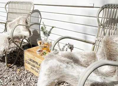 a patio with two chairs and a table with drinks at Duin Cottage Bergen in Bergen