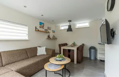 a living room with a couch and a table at Zomerhuis Het Hoekje in Egmond aan Zee