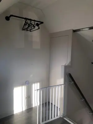 a staircase in a white room with a window at Zomerhuis Het Hoekje in Egmond aan Zee