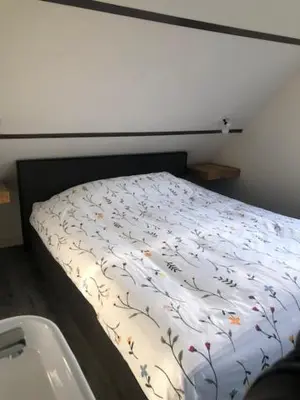 a bedroom with a bed and a bath tub at Zomerhuis Het Hoekje in Egmond aan Zee