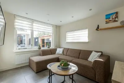 a living room with a couch and a table at Zomerhuis Het Hoekje in Egmond aan Zee