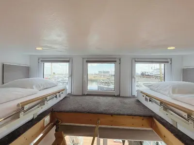 two beds in a room with two windows at Tiny lake houses near the beach and centre by Weltevreden Experience in Zeewolde