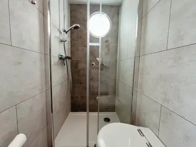 a bathroom with a shower with a toilet and a sink at Tiny lake houses near the beach and centre by Weltevreden Experience in Zeewolde