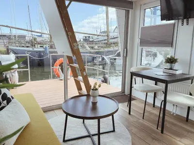 a living room with a view of a marina at Tiny lake houses near the beach and centre by Weltevreden Experience in Zeewolde