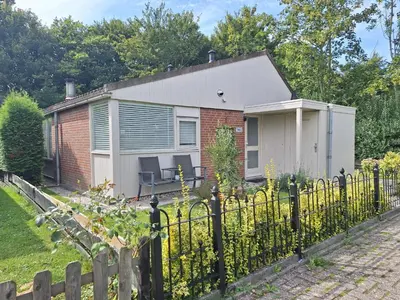 a small house behind a fence at Rekerlanden 104 in Schoorldam