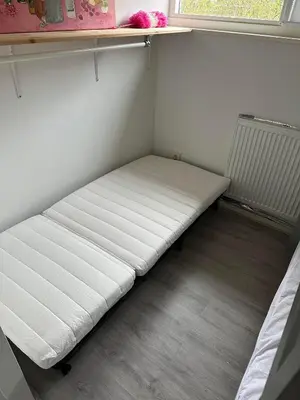 a white bed in a room with a window at Rekerlanden 104 in Schoorldam