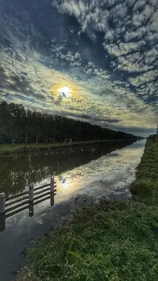 a view of a river with the sun reflecting in the water at Ecolodge Almere in Almere