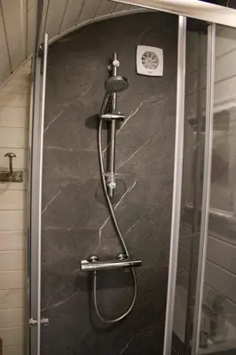 a shower with a hose attached to a wall at Ecolodge Almere in Almere