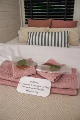 a couple of towels on a bed with a note at Ecolodge Almere in Almere