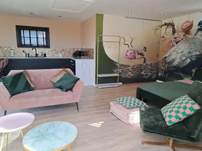 a living room with a couch and chairs and tables at Hooischuur Wakker in Eemnes