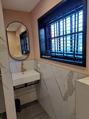 a bathroom with a sink and a mirror and a window at Hooischuur Wakker in Eemnes