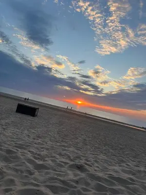 a box sitting on the beach at sunset at Vrije Vogels tuin met privacy in Warmenhuizen
