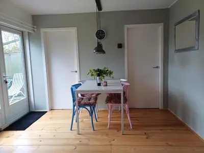a dining room with a table and chairs at Vrije Vogels tuin met privacy in Warmenhuizen