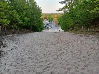 a sandy beach with people walking on it at Vrije Vogels tuin met privacy in Warmenhuizen