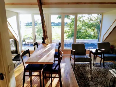 a dining room with a table and chairs and a large window at The Grutto, private apartment 25 min from city center in Amsterdam