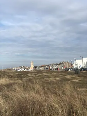 a field of grass with buildings in the background at Vakantiehuis in Katwijk aan zee in Katwijk aan Zee