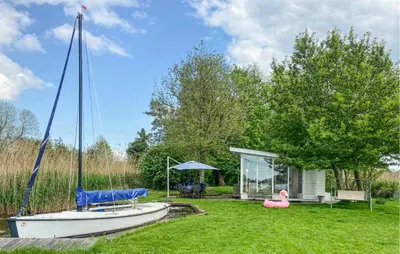 a small boat in a yard next to a house at Lakehouse Reeuwijk in Reeuwijk