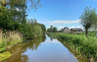 a river with a house in the middle of it at Lakehouse Reeuwijk in Reeuwijk