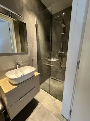 a bathroom with a sink and a glass shower at Homes by the C in Zandvoort